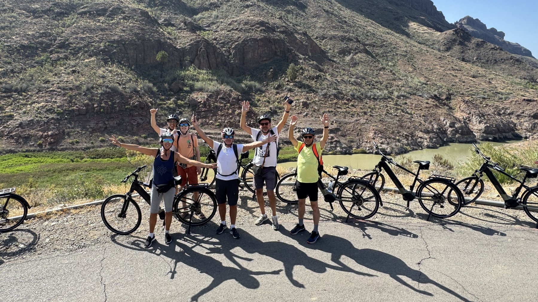 Groupe de cyclistes célébrant une balade à vélo électrique dans un paysage volcanique des Canaries