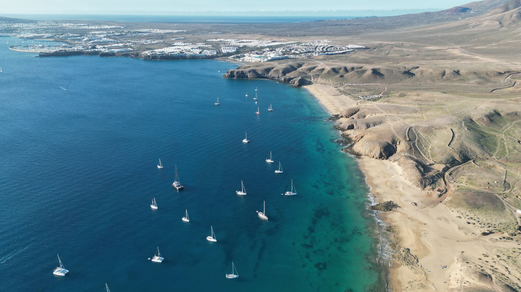 Vue aérienne de voiliers ancrés dans une baie turquoise de Lanzarote