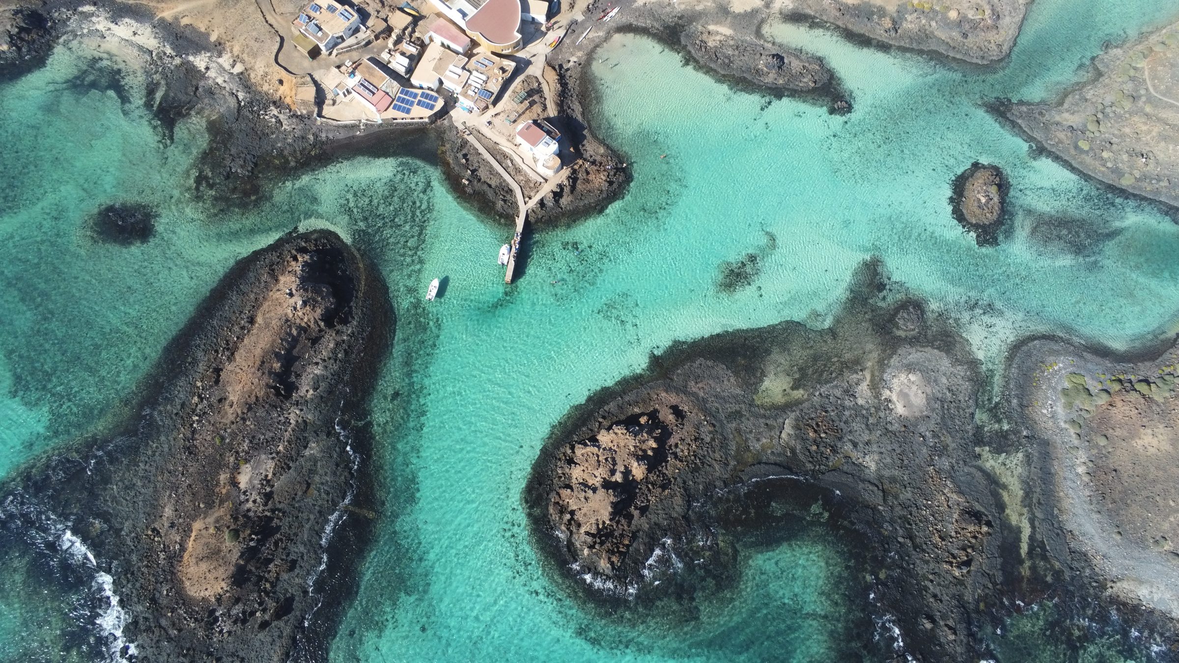 Vue aérienne des roches volcaniques et du lagon turquoise d'Isla de Lobos