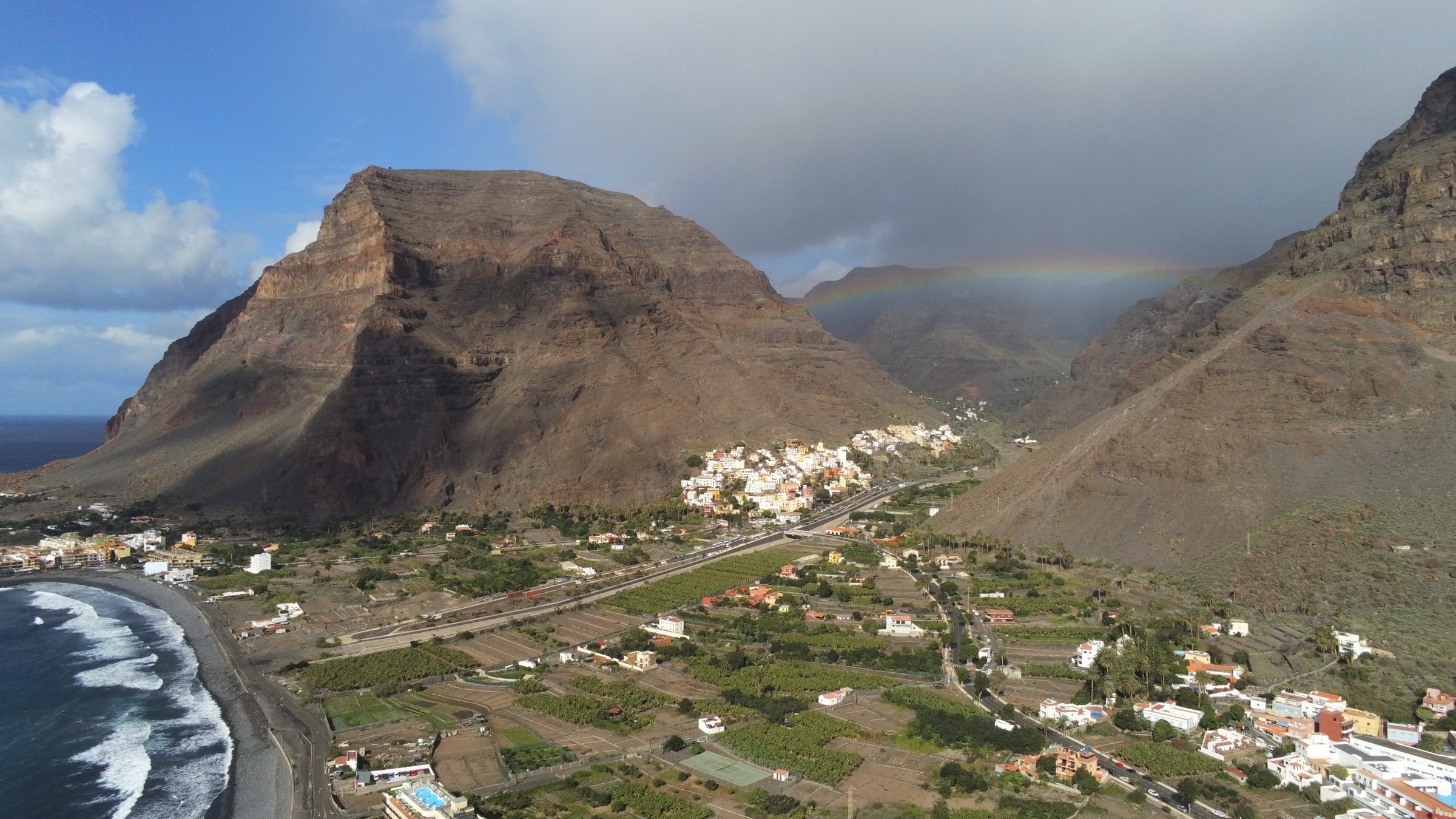 Vallée montagneuse et village de La Gomera avec arc-en-ciel, vue aérienne
